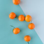 Top view of mandarins on a blue and green two-tone surface.